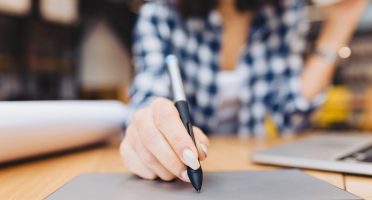 Closeup image hand of woman designing on table in library surround work stuff. Laptop, creative work, graphic design, freelancer, smart student, love job