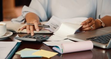Hands of female entrepreneur working with bills and documents